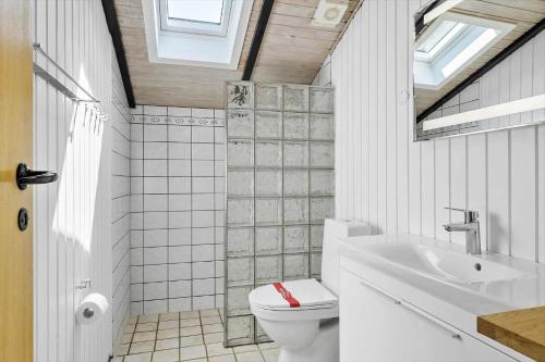 a bathroom with a toilet and a sink and a mirror at 0312-Romo-Vagtelvej-8 in Høm