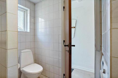 a white bathroom with a toilet and a shower at 0309-Romo-Stagebjergvej-13 in Høm