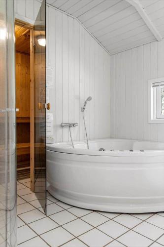 a white bathroom with a tub in a room at 0252-Romo-Kromosevej-6 in Høm