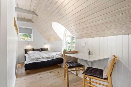 a bedroom with a bed and a desk in a room at 0209-Romo-Vrabyvej-34 in Høm