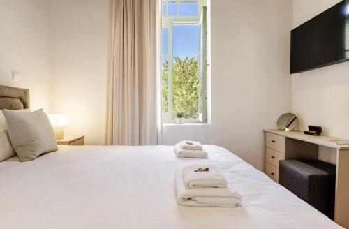 a bedroom with a large white bed with towels on it at Limisso Luxury Residence In city Center in Limassol