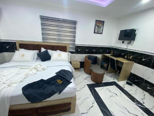 ein Schlafzimmer mit einem Bett und einem Fernseher in der Unterkunft Mathelm Hotel in Ikorodu