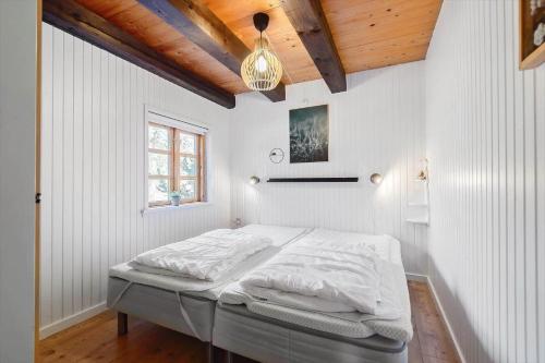 a white bedroom with a bed in a room at 0310-Romo-Langdalsvej-61 in Høm
