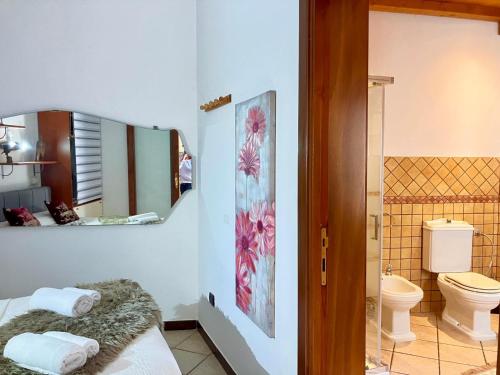 a bathroom with a toilet and a mirror at Splendido appartamento tra mare e storia in Sorso