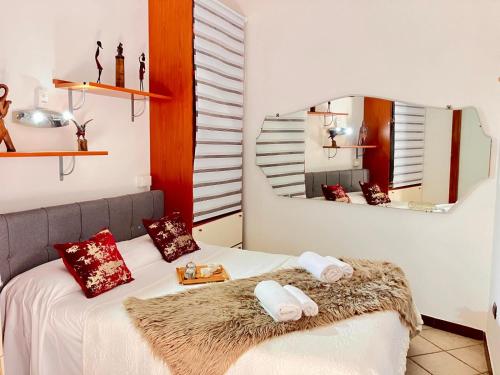 a bedroom with a bed with a mirror and towels at Splendido appartamento tra mare e storia in Sorso