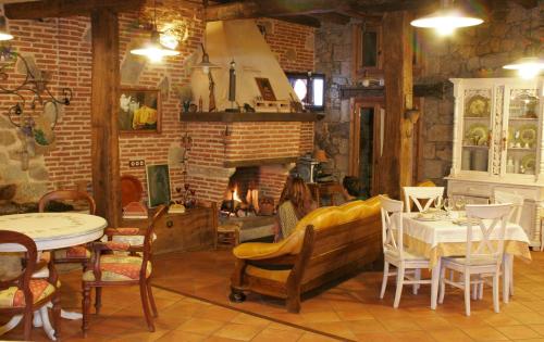 een kamer met een tafel en stoelen en een open haard bij Posada La Gatera in Pedro Bernardo
