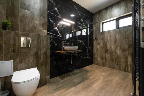a bathroom with a toilet and two sinks at Вила Bora Vista 1 in Tsigov Chark