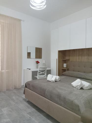 a bedroom with a large bed and a desk at Nel cuore di Segesta in Calatafimi