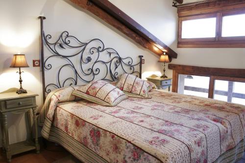 Un dormitorio con una cama grande y dos lámparas. en Posada La Gatera, en Pedro Bernardo