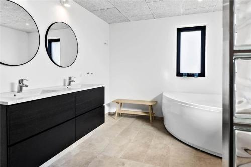 a bathroom with a tub and a sink and mirror at 0374-Romo-Vestergade-337 in Høm