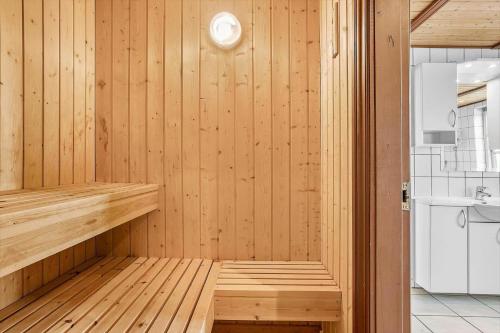 a sauna with wooden paneled walls and a kitchen at 0225-Romo-Kromosevej-22-A in Høm