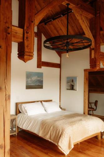 a bedroom with a large bed with a wooden ceiling at Fawn Crest -Timber Frame Retreat, Firepit, 20 acre in Alfred Station