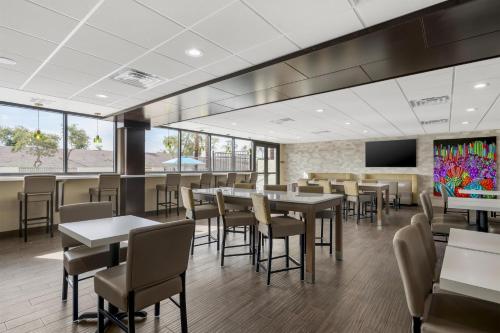 a dining room with tables and chairs and a tv at Best Western Plus Gilbert/Mesa in Mesa