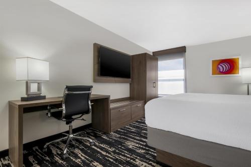 a hotel room with a bed and a desk with a computer at Best Western Plus Gilbert/Mesa in Mesa