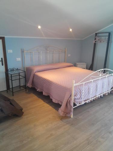 a bedroom with a bed with a pink bedspread at Mansarda a Noli e Spotorno in Noli