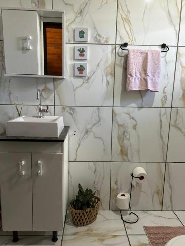 een badkamer met een wastafel en een marmeren muur bij Chalé Sossegado in Treviso