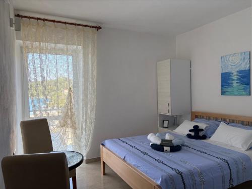 a bedroom with a bed and a window and a chair at Guesthouse Kamarin in Pomena