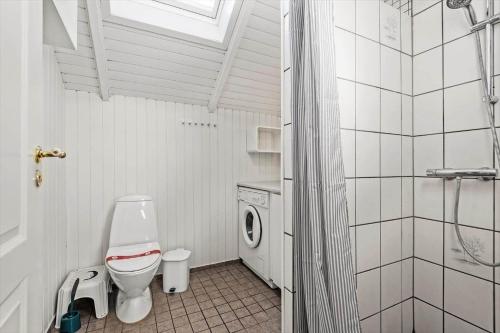 a white bathroom with a toilet and a shower at 0386-Romo-Vestergade-3-Ap-16 in Høm
