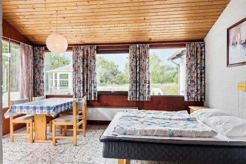 a bedroom with a bed and a table and chairs at 0357-Romo-Sonderstrandvej-21 in Høm