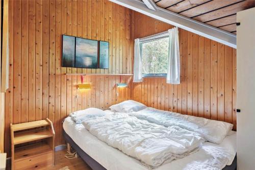 a bedroom with a bed in a wooden wall at 0146-Romo-Ejnar-Mikkelsensvej-16 in Høm