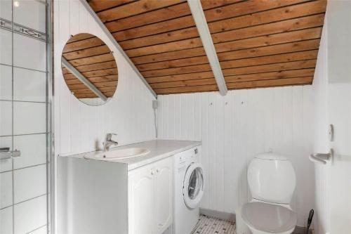 a bathroom with a sink and a washing machine at 0146-Romo-Ejnar-Mikkelsensvej-16 in Høm