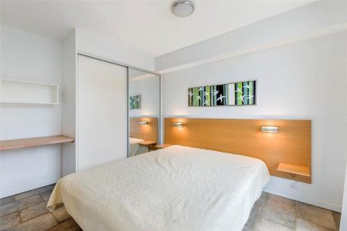 a bedroom with a white bed and a wooden headboard at 1356-Romo-Blaklokkevej-356 in Høm