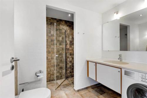 a bathroom with a sink and a washing machine at 1356-Romo-Blaklokkevej-356 in Høm