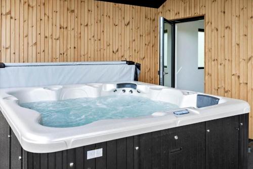a large bath tub with blue water in a bathroom at 0346-Romo-Vestergardsvaenget-11 in Høm
