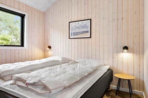 a bedroom with a large bed with white sheets at 0346-Romo-Vestergardsvaenget-11 in Høm