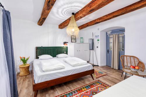 a bedroom with a bed with white sheets and wooden ceilings at Káli Kert Vendégház in Szentbékkálla
