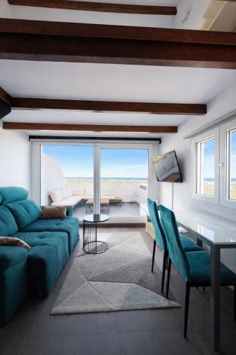 a living room with a blue couch and a table at Mediterranean View Apartment in Denia