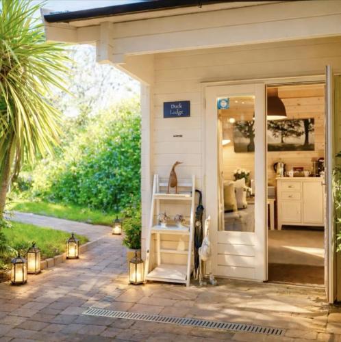 a white shed with lights on a patio at Duck Lodge B&B in Pyecombe