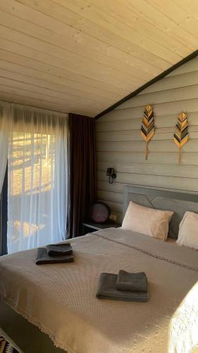 a bedroom with a bed with two towels on it at Гойра in Dzembronya