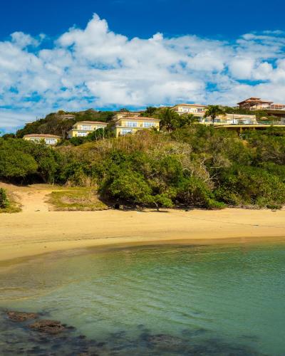 a view of a beach with houses on a hill at Uni Boutique Hotel & Spa in Búzios