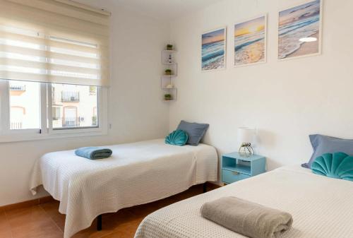 a bedroom with two beds and a window at Apartamento ROMA in Torre del Mar