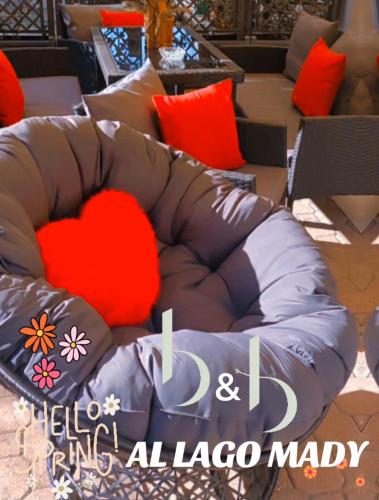 a brown couch with a red pillow in a living room at b&b al lago Mady in Avigliana