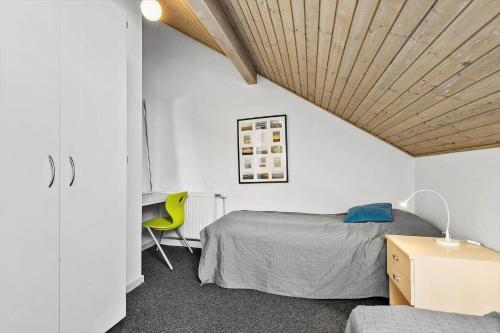 a bedroom with a bed and a yellow chair at 0353-Romo-Vestergade-155-B-Ap-130 in Høm