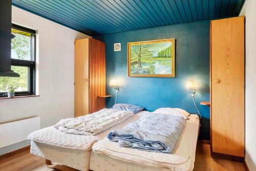a bedroom with two beds and a blue wall at 0187-Romo-Egedesminde-1 in Høm