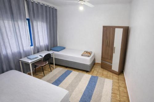 ein kleines Zimmer mit einem Bett und einem Schreibtisch in der Unterkunft Hotel Pousada Liberdade in Pindamonhangaba
