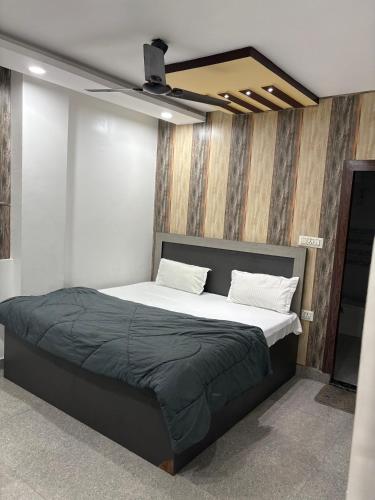 a bedroom with a large bed with a ceiling at Hotel Shivaay Inn in Kānpur