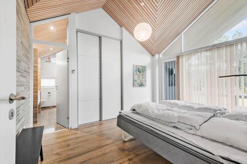 a bedroom with a bed and a large window at 0399-Romo-Strandskaden-22 in Høm