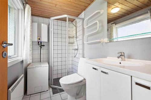 a white bathroom with a toilet and a sink at 0028-Romo-Blabaervej-28 in Høm