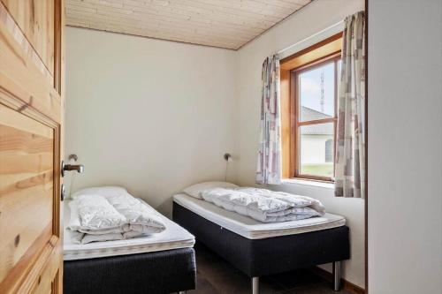 two beds in a room with a window at 0462-Romo-Romersvej-9-Ap-2 in Høm