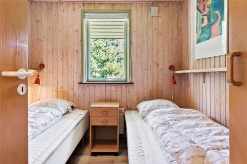two beds in a room with wooden walls at 0215-Romo-Vestergardsvej-8 in Høm