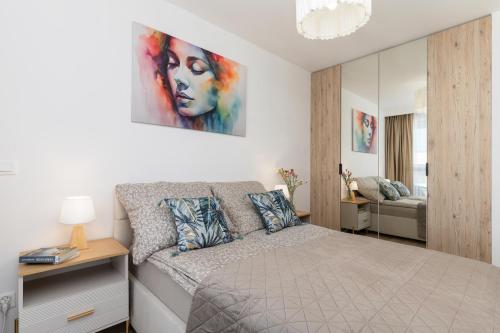 a bedroom with a bed and a painting on the wall at Apartament Sun&City in Bielsko-Biała