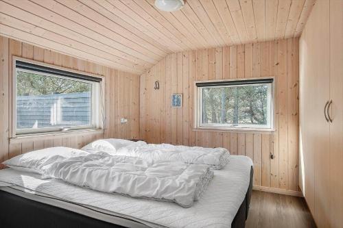 a large bed in a room with two windows at 0120-Romo-Smafolksvej-61 in Høm