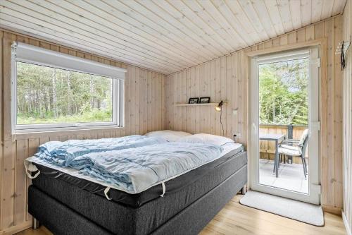 a bedroom with a bed and a window and a table at 0264-Romo-Lyngvejen-37 in Høm