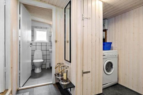 a bathroom with a toilet and a washing machine at 0264-Romo-Lyngvejen-37 in Høm