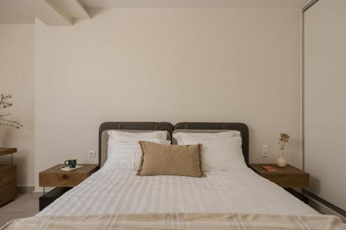a large bed with white sheets and pillows at Estia Urban Stay in Ioannina