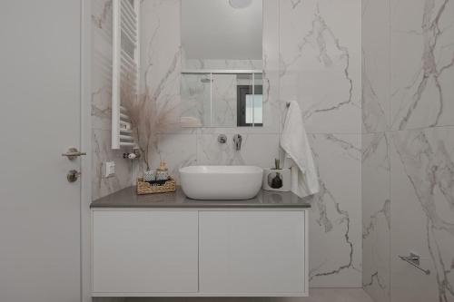 a white bathroom with a sink and a mirror at Estia Urban Stay in Ioannina